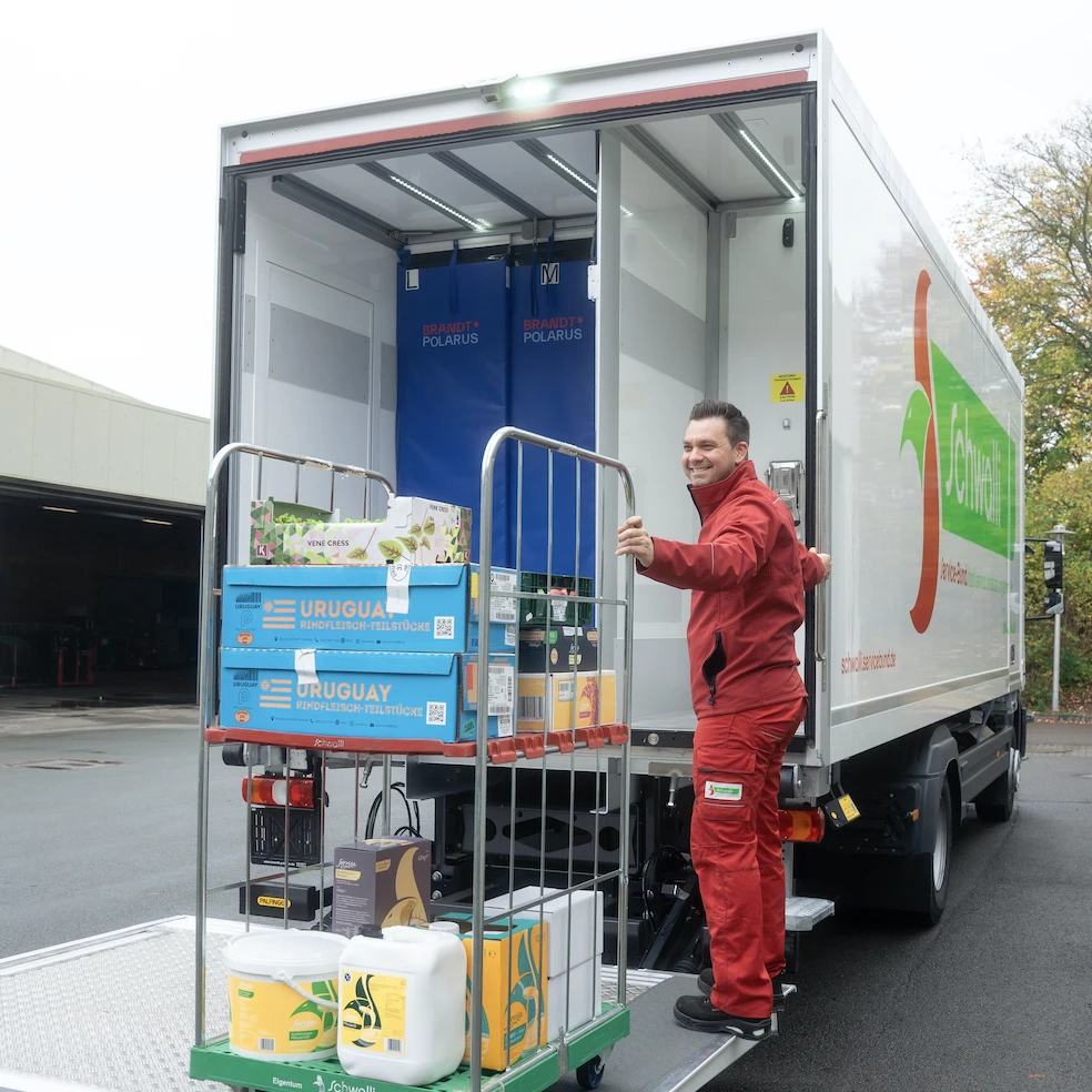 Auslieferung Mitarbeiter vor einem LKW-Fuhrpark