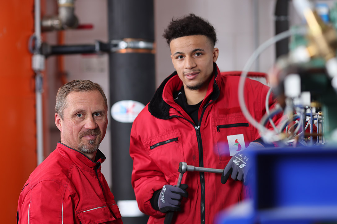 Unser Team Zwei Mitarbeitende schieben einen Rolli mit Ware in einen LKW