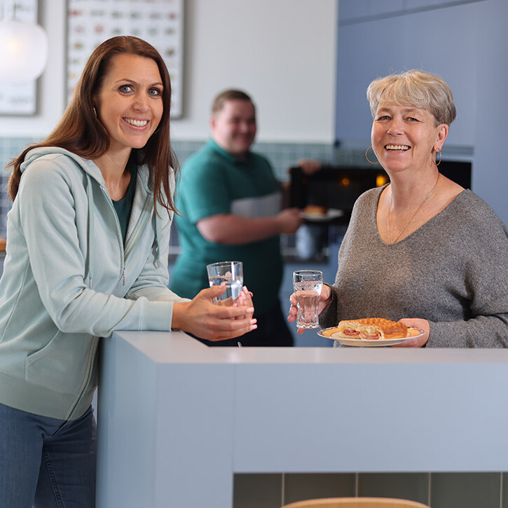 Frau zeigt Kaffee im Kundengespräch