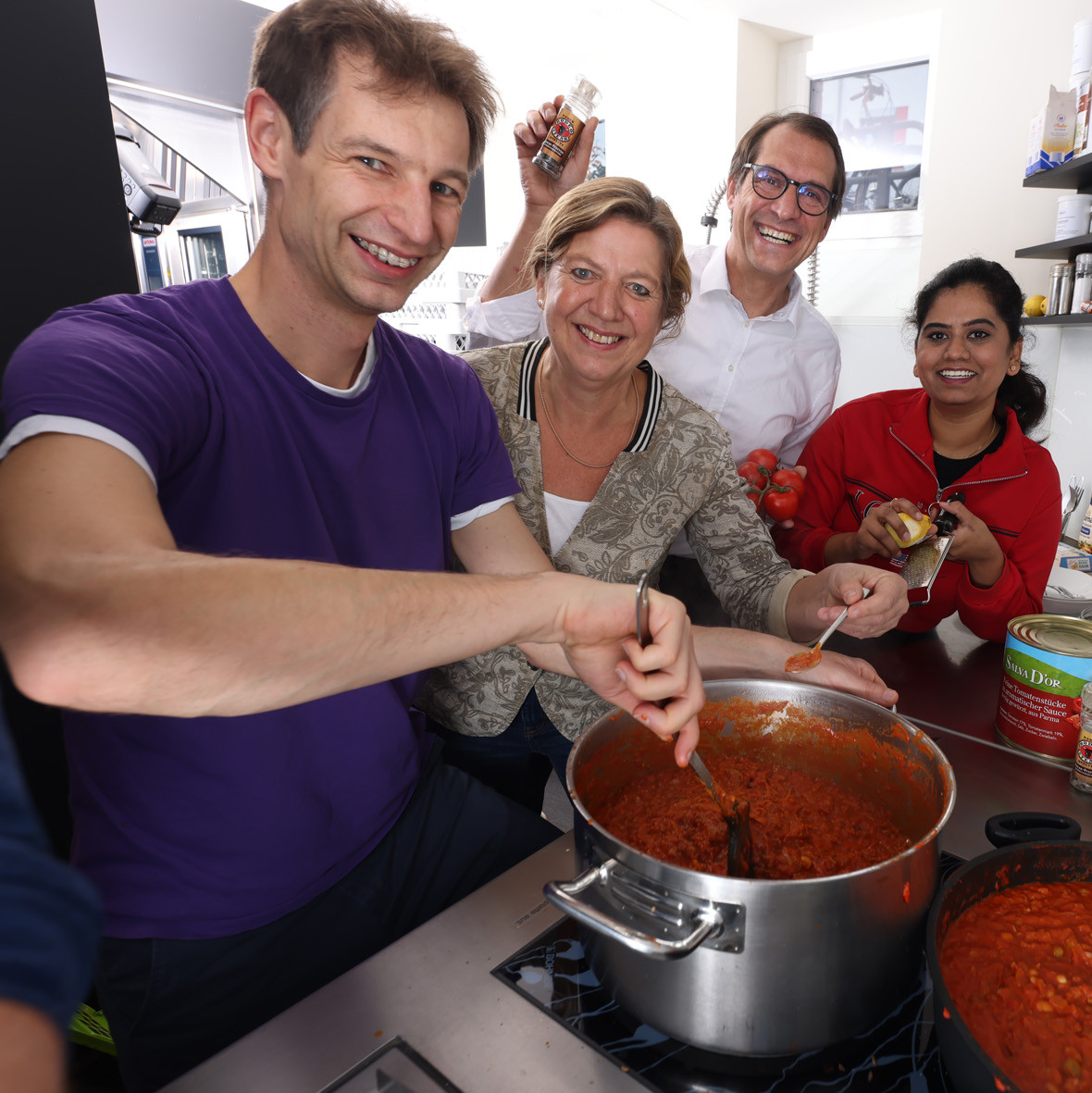 Mitarbeitende kochen gemeinsam Tomatensuppe