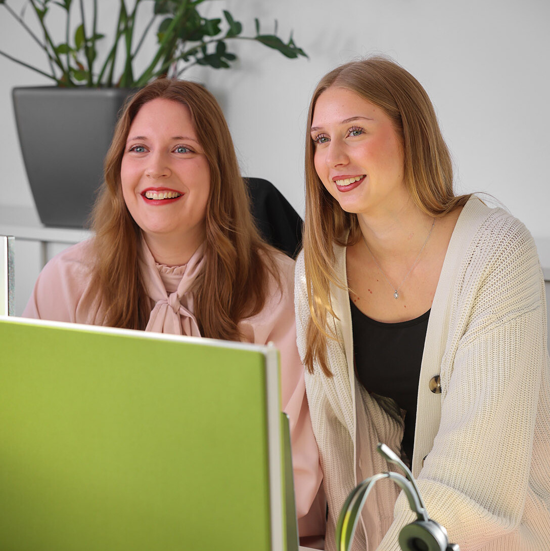 Mitarbeiterin lächelt in die Kamera.